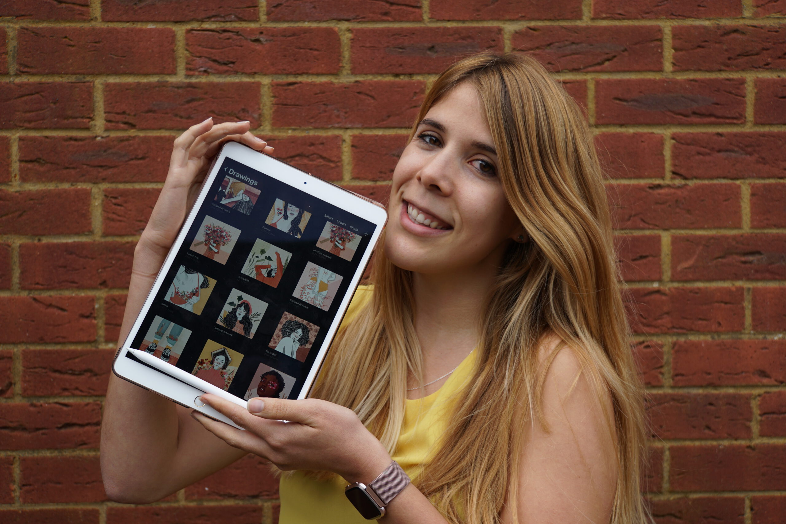 Retrato de Marina sosteniendo su iPad junto con sus ilustraciones digitales